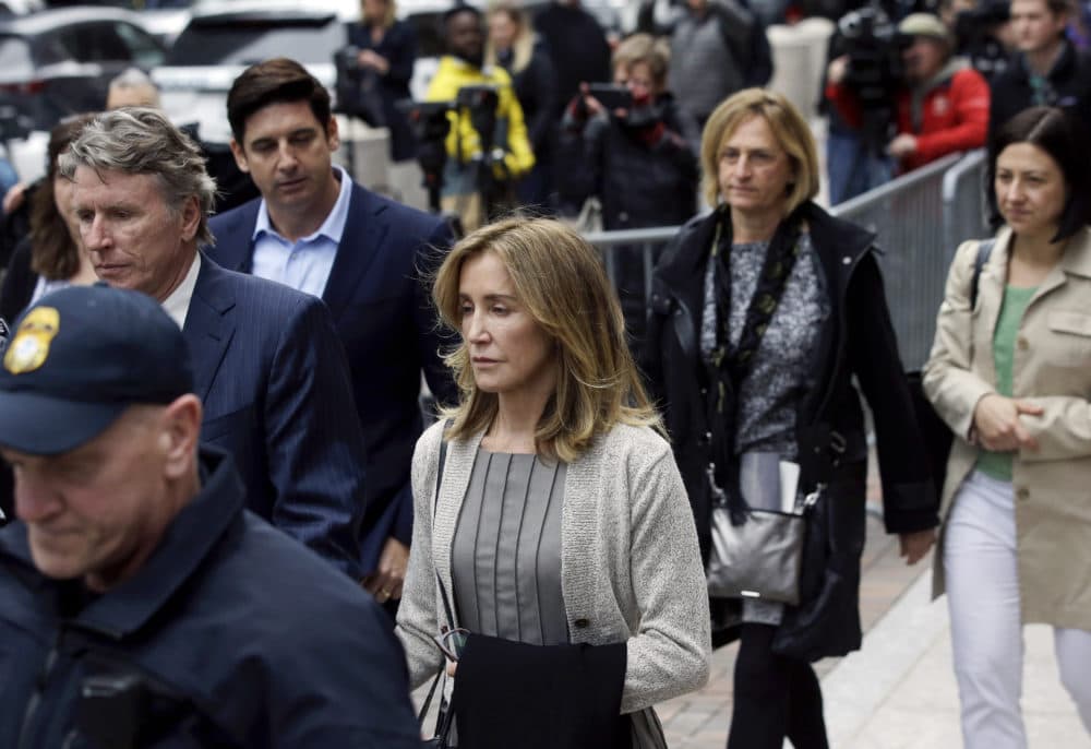 Felicity Huffman, center, departs Boston federal court with her brother, left, on Monday after she pleaded guilty to charges in a nationwide college admissions bribery scandal. (Steven Senne/AP)