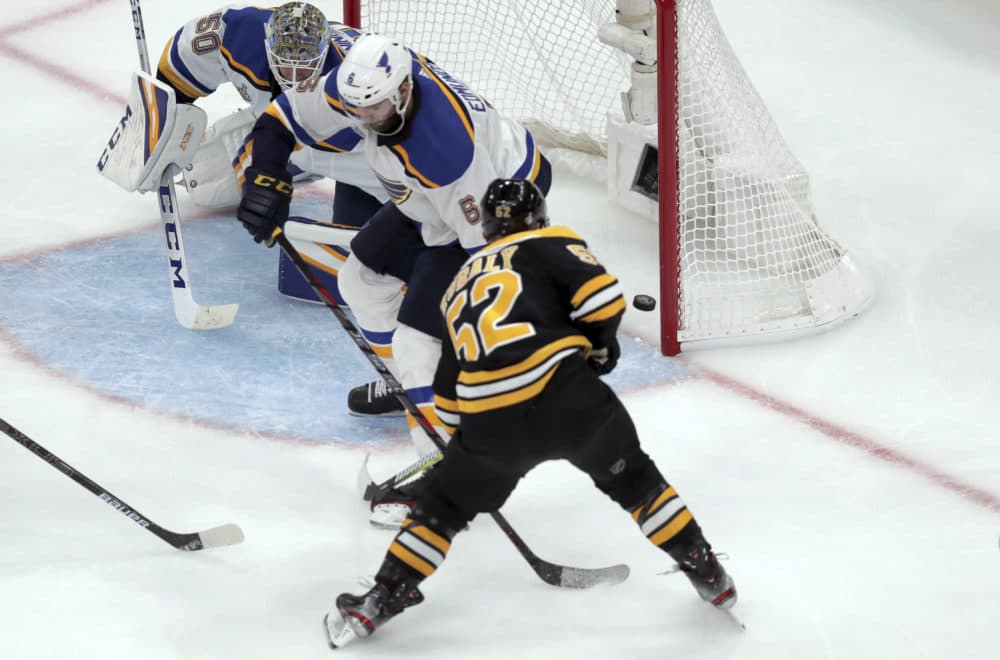 Boston Bruins' Sean Kuraly scores a goal past St. Louis Blues goaltender Jordan Binnington and Joel Edmundson (6) during the third period in Game 1 in Boston. (Charles Krupa/AP)