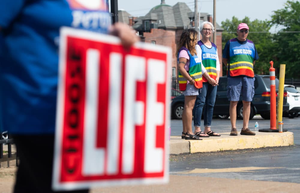 Clinic escorts stand in the parking lot as anti-abortion demonstrators hold a protest outside the Planned Parenthood Reproductive Health Services Center in St. Louis on May 31, 2019, the last location in the state performing abortions. (Saul Loeb/AFP/Getty Images)