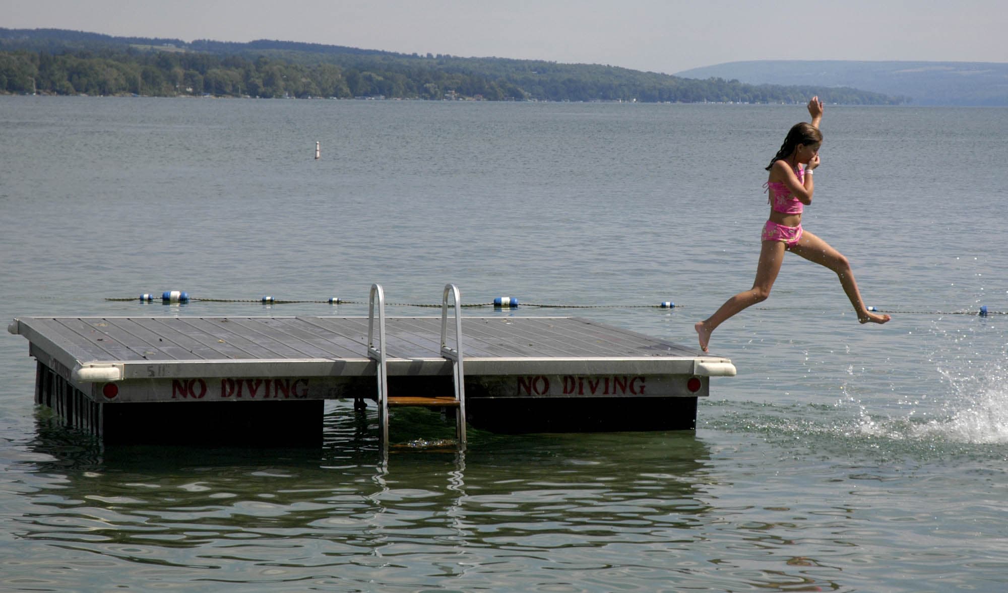 A young swimmer jumps into Skaneateles Lake in Skaneateles, N.Y. The small lakeside town in upstate New York's Finger Lakes is just one of many destinations you could consider visiting this summer. (Kevin Rivoli/AP)