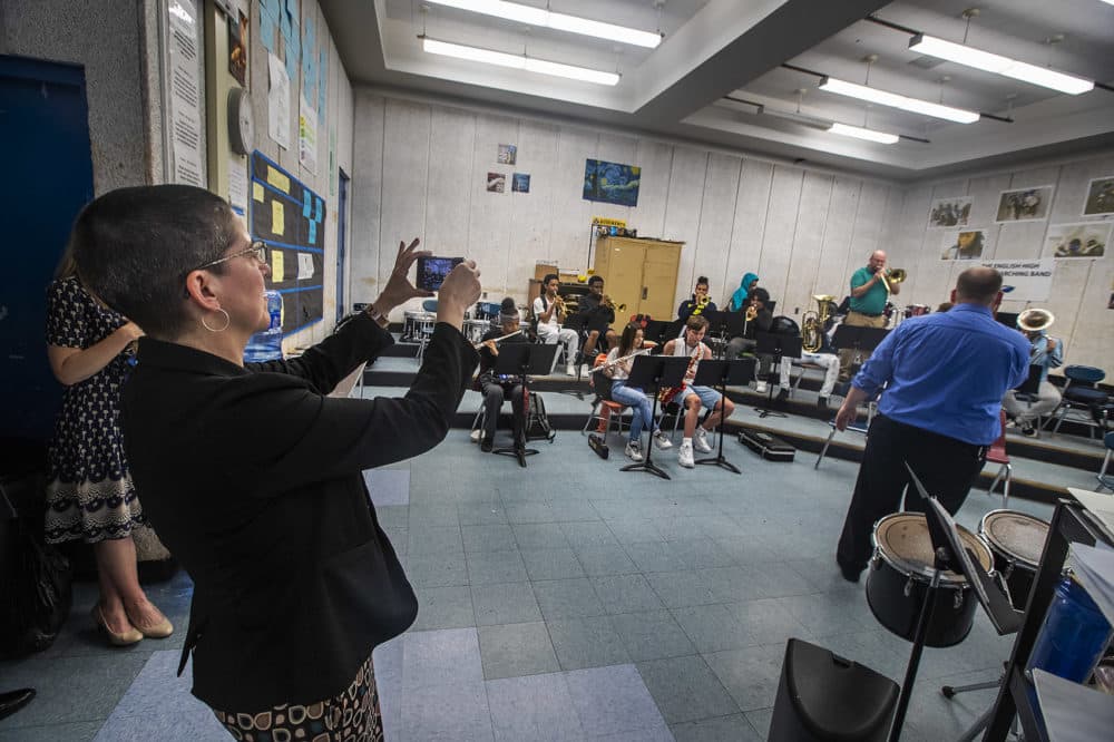 Laura Perille snaps a photo during a rehearsal for English High's marching band, the only marching band at a Boston public school. (Jesse Costa/WBUR)