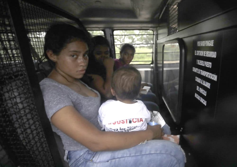 A Honduran woman holds her one-year-old in the back of a transport van after surrendering to U.S. Border Patrol agents Monday, June 25, 2018, near McAllen, Texas. (David J. Phillip/AP)