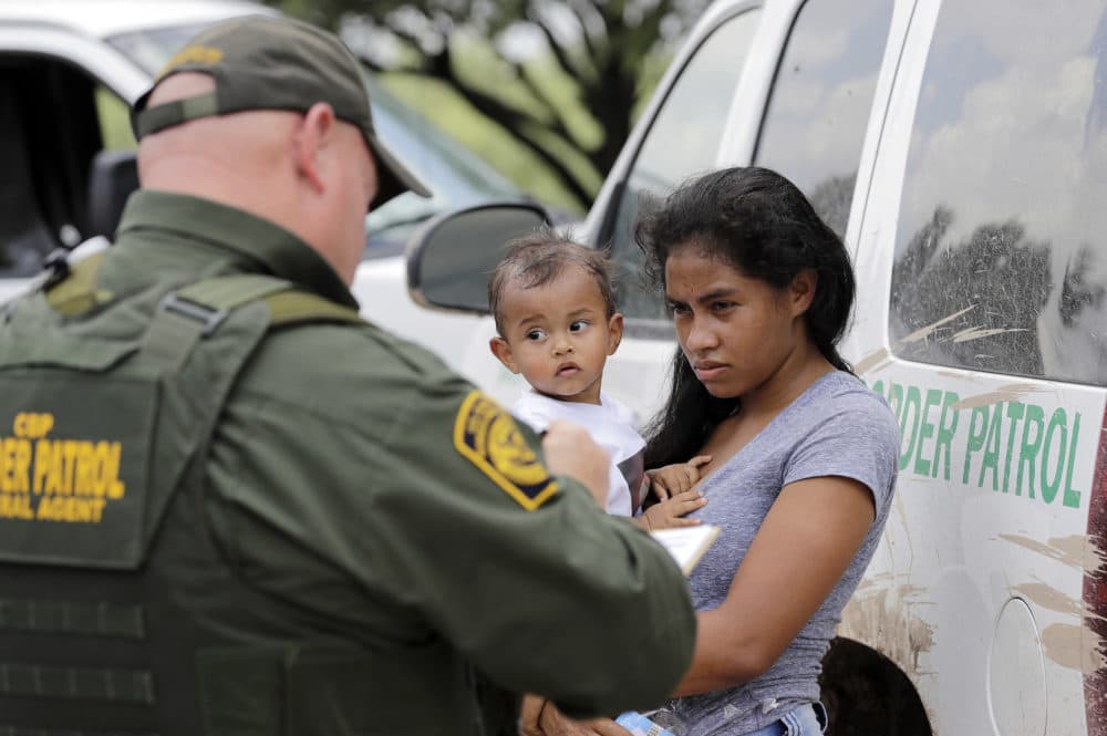 In this June 25, 2018 file photo, a woman from Honduras and her 1-year-old child surrender to U.S. Border Patrol agents after crossing the border, near McAllen, Texas. (David J. Phillip/AP)