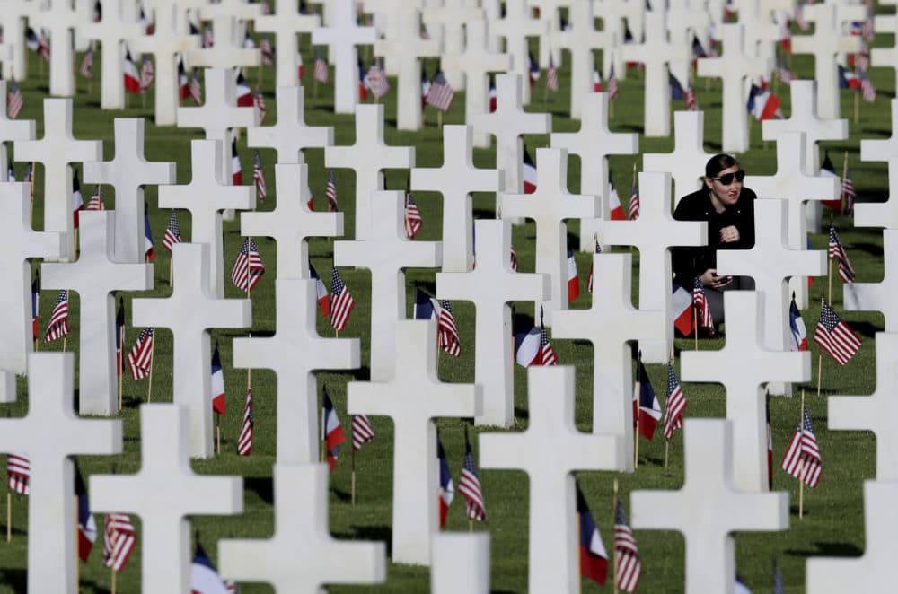A young woman visits headstones of World War II soldiers prior to a ceremony to mark the 75th anniversary of D-Day at the Normandy American Cemetery in Colleville-sur-Mer, Normandy, France, Thursday, June 6, 2019. World leaders are gathered Thursday in France to mark the 75th anniversary of the D-Day landings. (David Vincent/AP)
