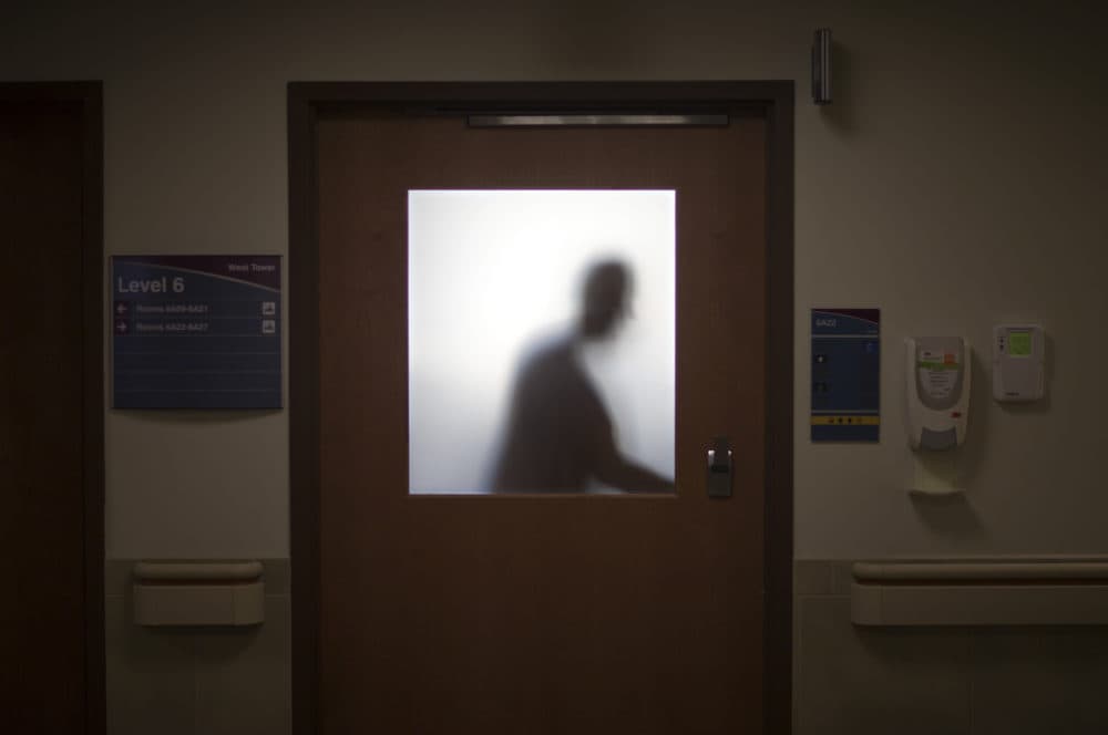 In this Jan. 24, 2014 photo, a doctor is silhouetted against a glass window while leaving an exam room after visiting a patient at Grady Memorial Hospital, in Atlanta. (David Goldman/AP)