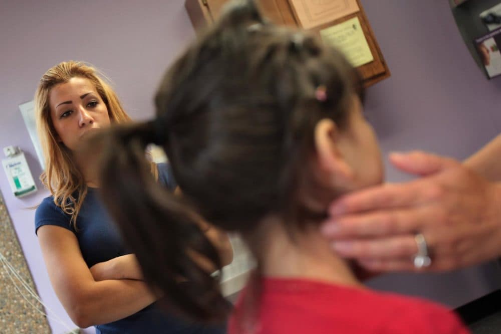 Jessica Mejia (left) watches as her sick daughter Joselyn, age 4, is checked at a low-cost clinic run by the Rocky Mountain Youth Clinics on July 28, 2009 in Aurora, Colo. (John Moore/Getty Images)