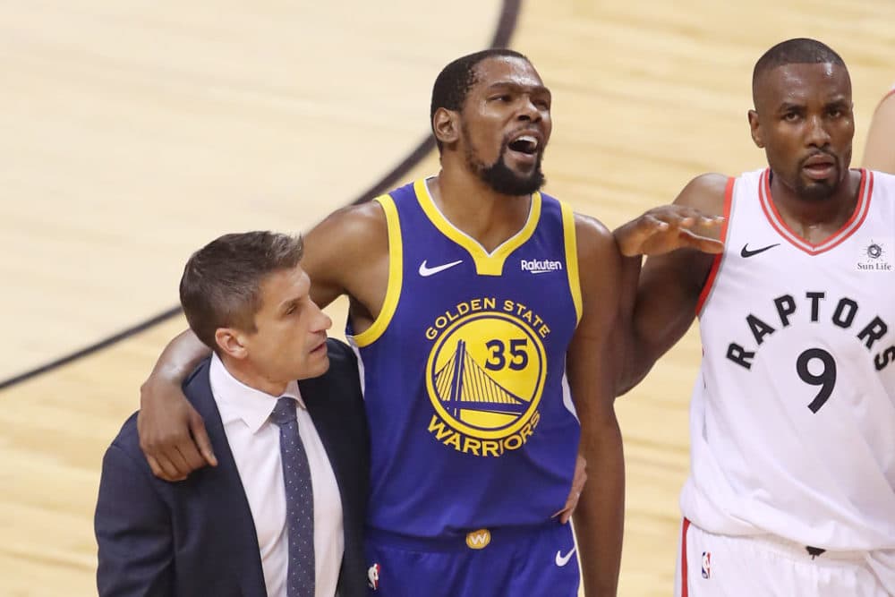 Kevin Durant is assisted off the court after an injury in the 2019 NBA Finals. (Claus Andersen/Getty Images)