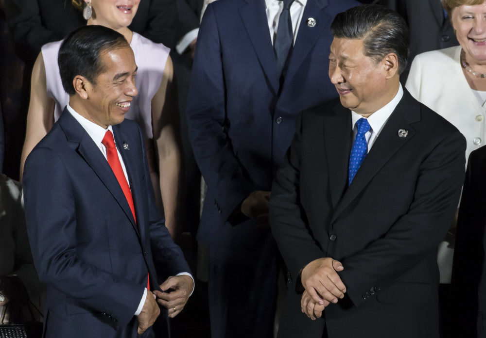 Indonesia's President Joko Widodo (left) speaks to China's President Xi Jinping during a photo session at the G-20 summit in Osaka, Japan. (Tomohiro Ohsumi/Getty Images)