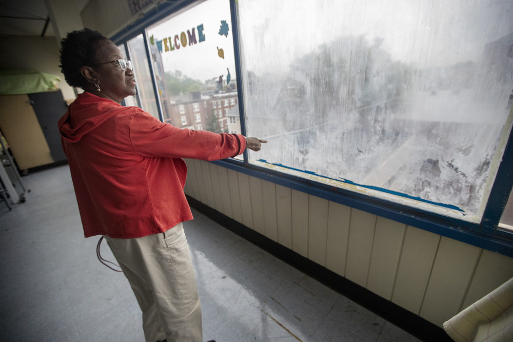 Anita Moore, Principal of Jackson Mann K-8 School, points out damage caused by leaking windows. (Jesse Costa/WBUR)