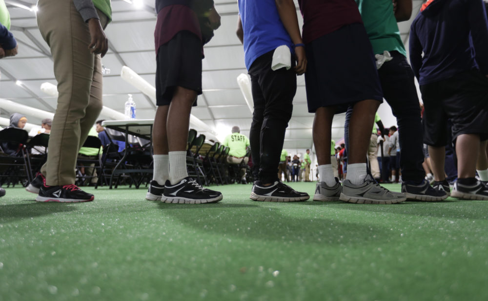 In this July 9, 2019 photo, immigrants line up in the dinning hall at the U.S. government's newest holding center for migrant children in Carrizo Springs, Texas. (Eric Gay/AP)