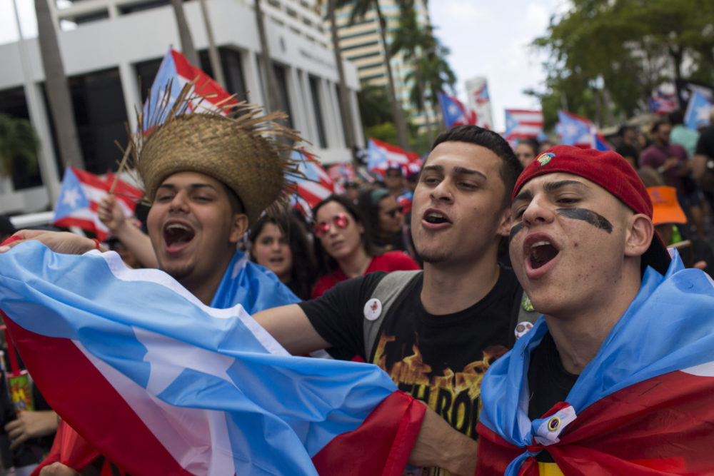 A trio of men sing during a march to celebrate the resignation of Gov. Ricardo Rossello in San Juan, Puerto Rico. (Dennis M. Rivera Pichardo/AP)