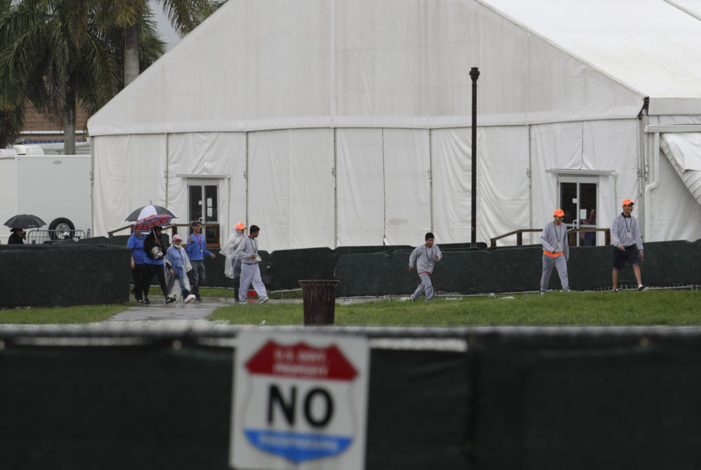 Migrant children and employees walks on the grounds of the Homestead Temporary Shelter for Unaccompanied Children on June 16 in Homestead, Fla. (Lynne Sladky/AP)