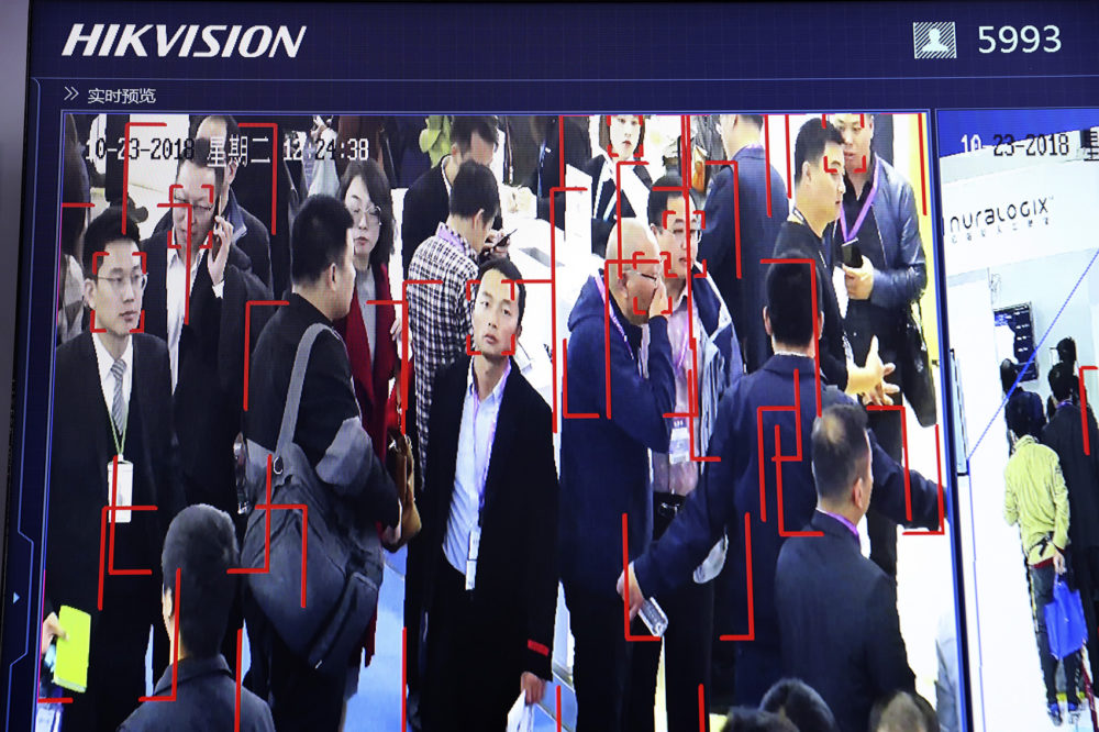 In this photo taken Tuesday, Oct. 23, 2018, visitors are tracked by facial recognition technology from state-owned surveillance equipment manufacturer Hikvision at the Security China 2018 expo in Beijing, China. The Chinese video surveillance company says it is taking concern about the use of its technology seriously following a report that the U.S. may block several Chinese surveillance companies from buying American components. (Ng Han Guan/AP)