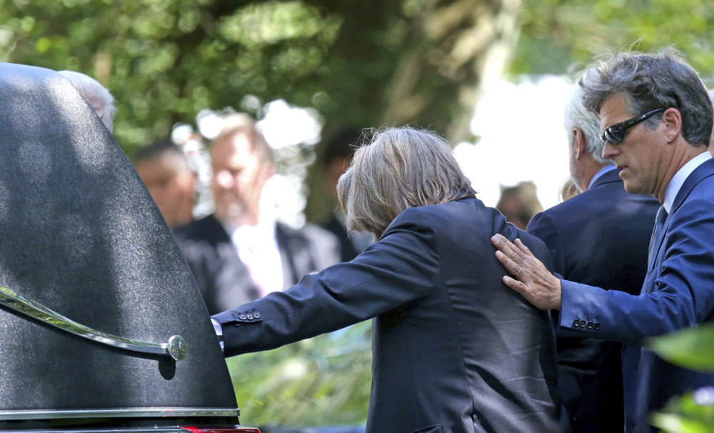 Paul Michael Hill, left, father of Saoirse Kennedy Hill, is consoled while his hand rests on the hearse at funeral services for his daughter on Monday, Aug. 5. (David L Ryan/The Boston Globe via AP)