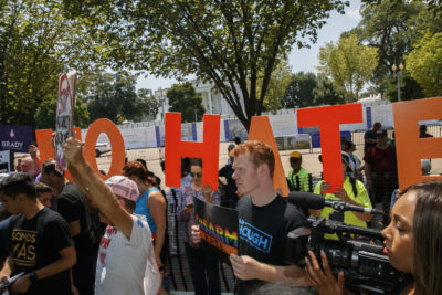 Adam Friedman, 19, a youth organizer with the Brady Campaign To Prevent Gun Violence, holds a sign saying &quot;Disarm Hate&quot;  during a rally against racism, and in favor of gun laws on Aug. 6 in Washington. (Jacquelyn Martin/AP)