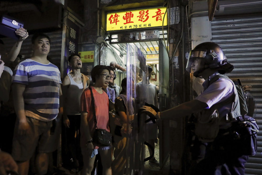 Residents watch policemen arresting people on a street during a face off at Sham Shui Po district in Hong Kong, Wednesday, Aug. 7, 2019. (Kin Cheung/AP)