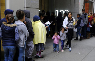 In this Jan. 31, 2019, file photo, hundreds of people overflow onto the sidewalk in a line snaking around the block outside a U.S. immigration office with numerous courtrooms in San Francisco. Santa Clara and San Francisco have filed suit against the Trump administration over its new controversial &quot;public charge&quot; rule that restricts legal immigration. This lawsuit is the first after the Department of Homeland Security's announcement Monday, Aug. 12, 2019, that it would deny green cards to migrants who use Medicaid, food stamps, housing vouchers or other forms of public assistance. (Eric Risberg/AP)