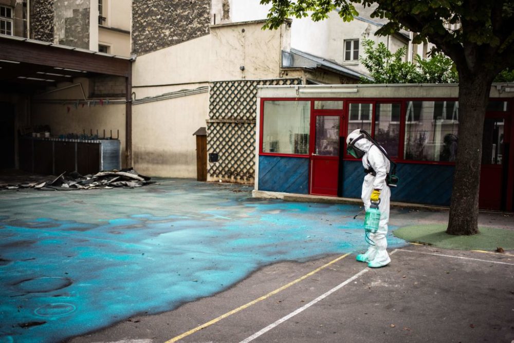 A worker sprays a gel on the ground to absorb lead as he takes part in a clean-up operation at Saint Benoit school near Notre Dame cathedral during a decontamination operation on August 8, 2019. (Martin Bureau/AFP/Getty Images)
