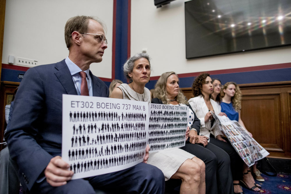 Michael Stumo and his wife Nadia Milleron, who lost their 24-year-old daughter in the March 2019 Ethiopian Airlines crash, hold up signs depicting those lost in the crash and on Lion Air Flight 610 during a congressional hearing in Washington, D.C. (Andrew Harnik/AP)