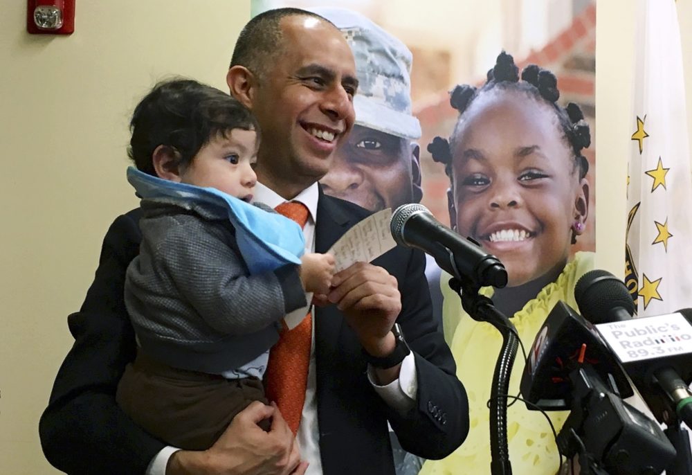 Mayor Jorge Elorza holds his son Omar during a news conference in Providence, R.I. (Steve Klamkin/WPRO News via AP)