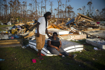 Synobia Reckley pauses on a wet mattress as her husband Dexter Edwards consoles her amid the remains of their home destroyed by Hurricane Dorian in Rocky Creek East End, Grand Bahama, Bahamas, Sunday, Sept. 8, 2019. The couple married two days after Hurricane Mathew hit in 2016 but did not do serious damage. (Ramon Espinosa/AP)