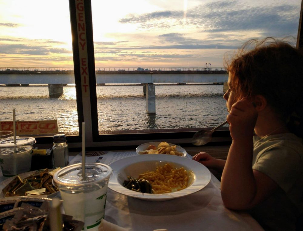 Transportation analyst Seth Kaplan's daughter enjoys macaroni and cheese with a view while riding in an Amtrak dining car. (Photo by Seth Kaplan/Here & Now)