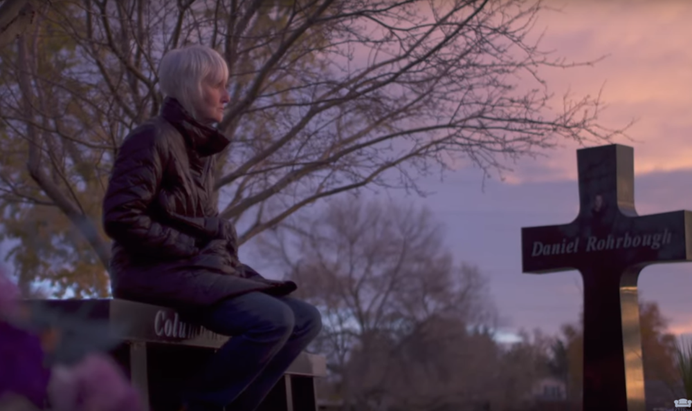 In this screenshot from American Tragedy, Sue Klebold sits at the memorial for the lives lost at Columbine.