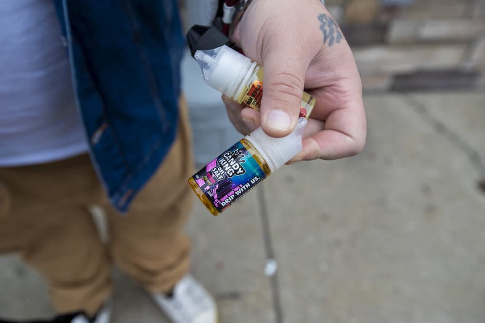 Dennis Yebba made the trip up to Salem, NH and holds three bottles of vaping juice just purchased at Smoker Cohoice including the cotton candy flavored Pink Squares Ejuice by Candy King. (Jesse Costa/WBUR)