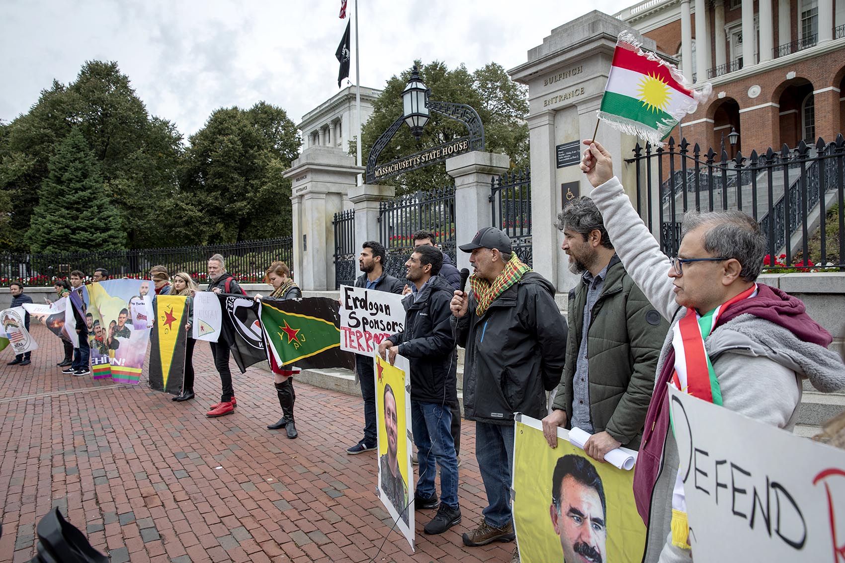 Protesters at a rally organized by two New England Kurdish associations chant and wave banners in front of the Massachusetts State House. (Robin Lubbock/WBUR)