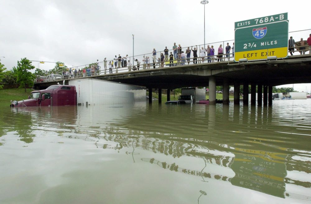 Onlookers stand on an overpass where flood waters have covered Interstate 10 in Houston, Saturday, June 9, 2001. (AP Photo/Eric Gay)