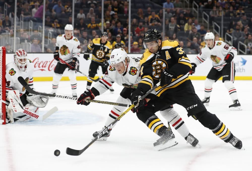 Boston Bruins' Patrice Bergeron tries to hold off Chicago Blackhawks' Adam Boqvist during the first period of an NHL preseason hockey game, Sept. 28, 2019, in Boston. (Winslow Townson/AP)