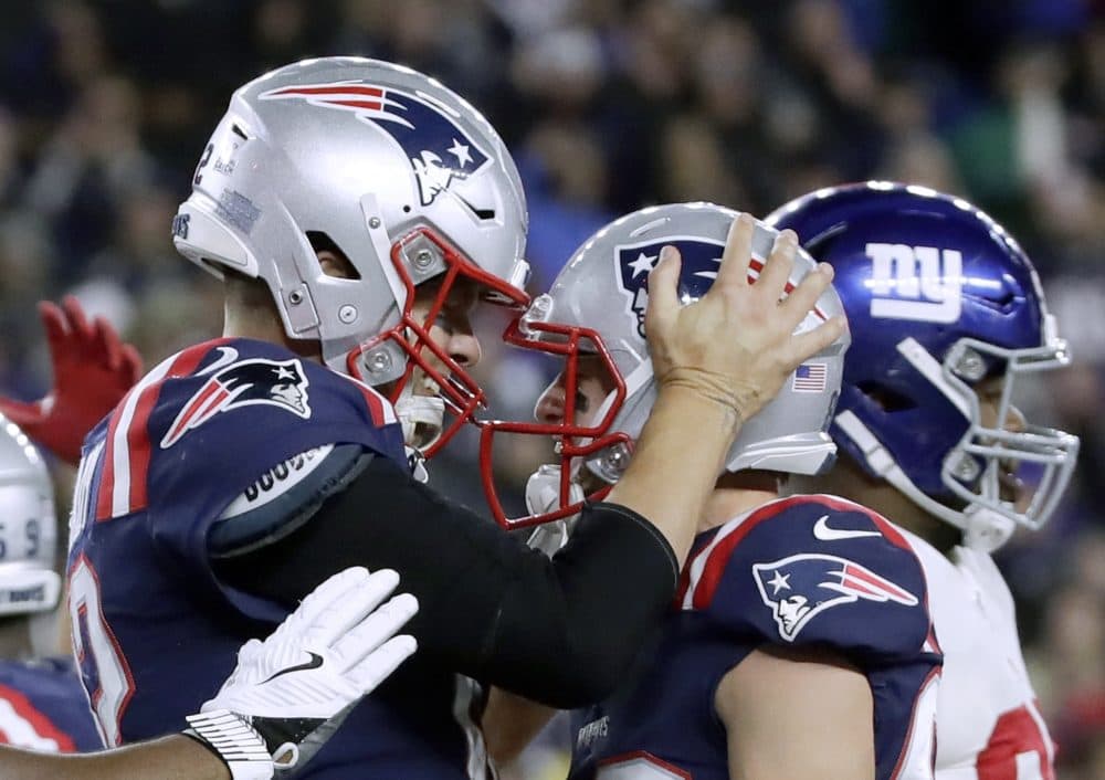 New England Patriots quarterback Tom Brady, left, celebrates his touchdown with Gunner Olszewski after scoring on a quarterback sneak in the second half of the game against the New York Giants on Thursday. (Elise Amendola/AP)