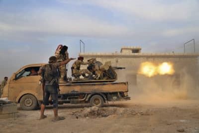 In this Monday, Oct. 14, 2019 photo, Turkey-backed Syrian opposition fighters fire a heavy machine-gun towards Kurdish fighters, in Syria's northern region of Manbij. Syrian state media said Tuesday that government forces have entered the center of the once Kurdish-held northern town of Manbij and raised the national flag. (AP Photo)