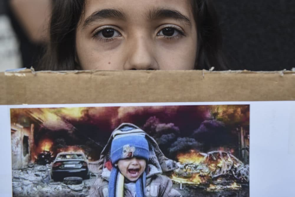 A Kurdish girl looks on as she holds a picture during a protest in the northern city of Thessaloniki, Greece, on Thursday. Oct. 17, 2019. (Giannis Papanikos/AP)