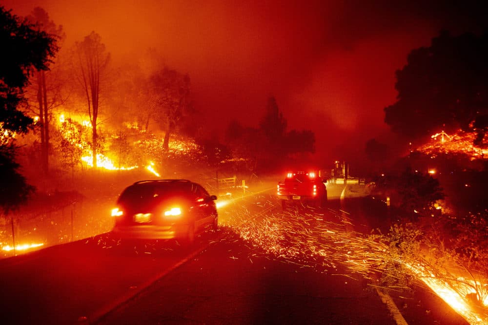 Embers fly across a roadway as the Kincade Fire burns through the Jimtown community of Sonoma County, Calif., on Thursday. (Noah Berger/AP)