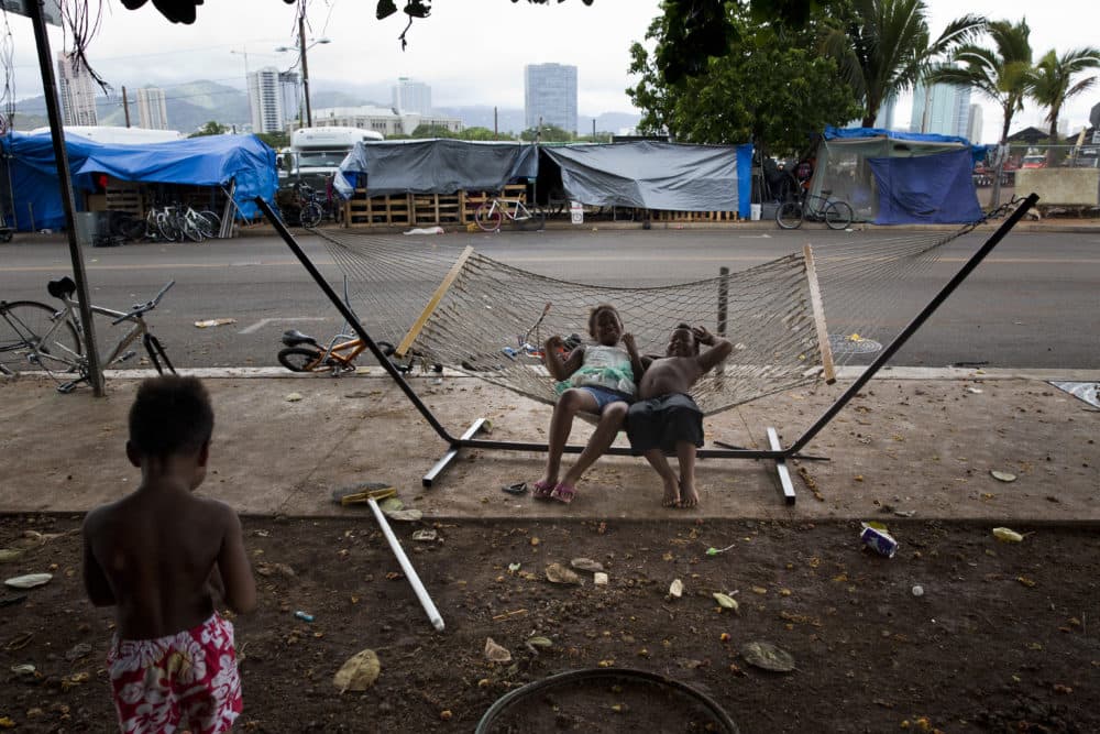 In this 2015 photo, two children rest on a hammock at a homeless encampment in the Kakaako district of Honolulu. Homelessness in Hawaii has grown in recent years, leaving the state with 487 homeless per 100,000 people, the nation's highest rate per capita, according to federal statistics. (Jae C. Hong/AP)