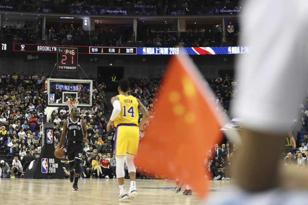 A fan waves a Chinese national flag during a preseason NBA game at the Mercedes Benz Arena in Shanghai, China, on Oct. 10, 2019. (AP)