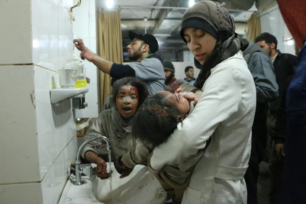 Dr. Amani (R) treats an injured baby among other medical staff and victims in Al Ghouta, Syria. (National Geographic)