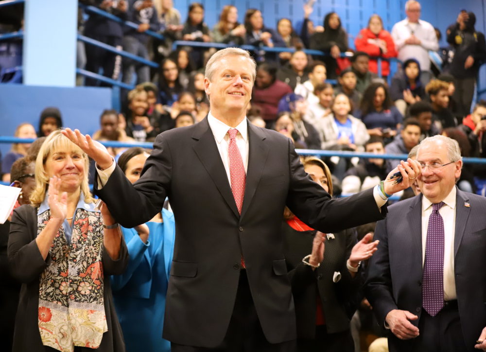 Gov. Charlie Baker gestures to the audience in the gymnasium of Boston's English High School after signing a landmark education funding reform law on Tuesday. (Sam Doran/SHNS)