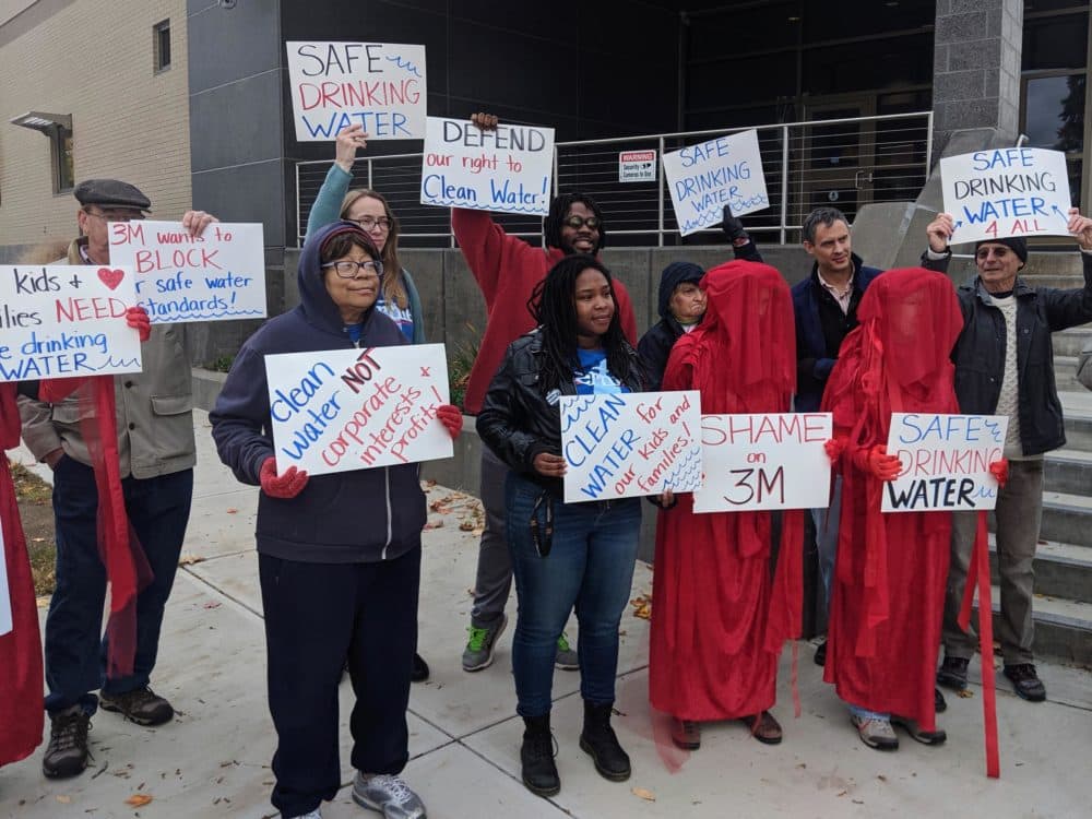 Drinking water advocates protested in Concord before a court hearing with 3M and the state earlier this fall. Some protesters wore red cloaks in support of the Extinction Rebellion movement. (Annie Ropeik/NHPR)