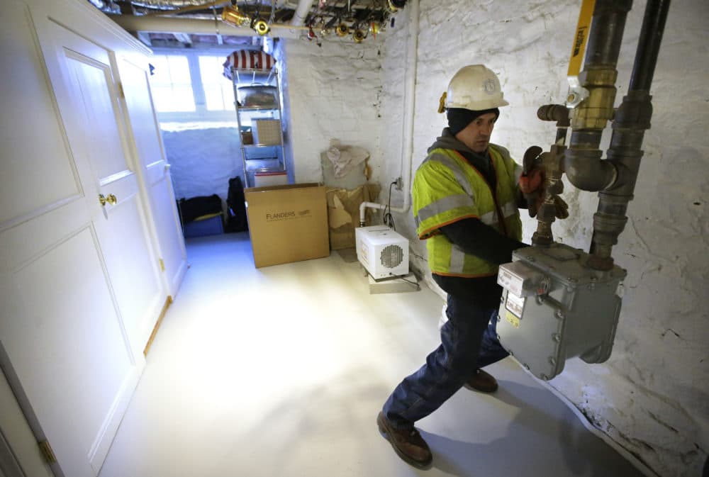 Joe Cabral, a sub-contractor for National Grid, uses a wrench to turn off the main natural gas line to a home, Tuesday, Jan. 22, 2019, in Newport, R.I. (Steven Senne/AP)