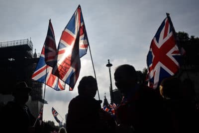 Pro-Brexit activists wave British flags outside the Houses of Parliament on Thursday — what would have been the day that the United Kingdom left the European Union. (Peter Summers/Getty Images)