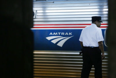 A train conductor stands next to an Amtrak train at New York's Pennsylvania Station. (Spencer Platt/Getty Images)