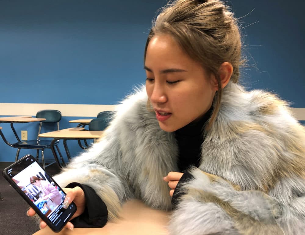 Xiwen Zheng browses fashion discounts between classes at Boston University's Center for English Language & Orientation Programs. (Callum Borchers/WBUR)