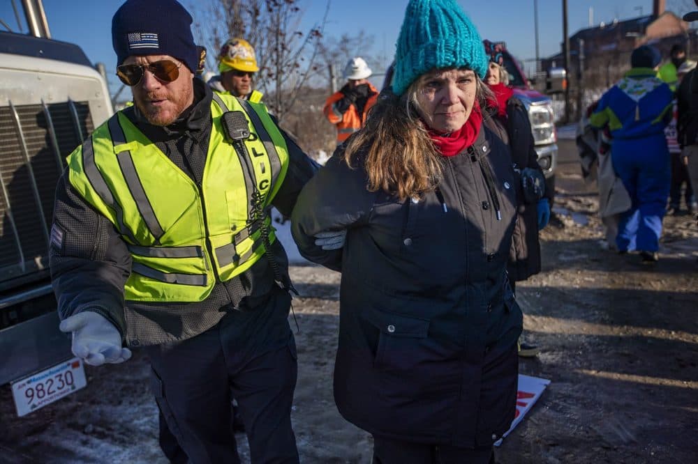 Weymouth Police officers arrest Lisa Jennings during a protest outside of the natural gas compressor construction site. (Jesse Costa/WBUR)