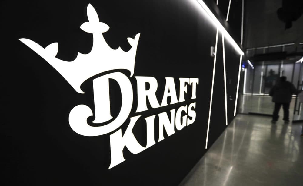 A worker passes logos at the DraftKings sports betting company headquarters in May in Boston. (Charles Krupa/AP)