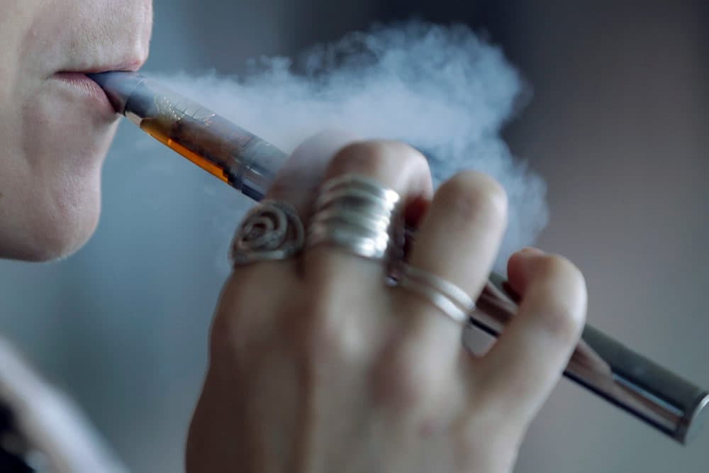 In this Oct. 4, 2019 AP file photo, a woman using an electronic cigarette exhales a puff of smoke in Mayfield Heights, Ohio. On Thursday, Oct. 31, 2019, the Centers for Disease Control and Prevention said that 1,888 confirmed and probable cases have been reported in 49 states. That includes 37 deaths in 24 states. (Tony Dejak/AP Photo)