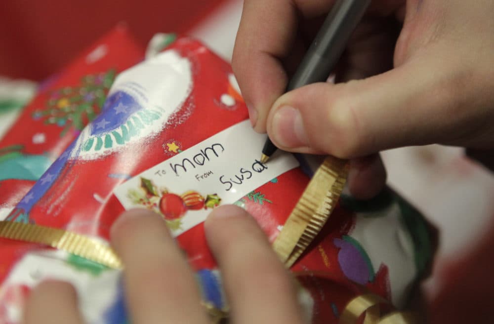 In this Dec. 17, 2010 photo, a young girl writes a gift tag for her mother. (Jae C. Hong/AP)