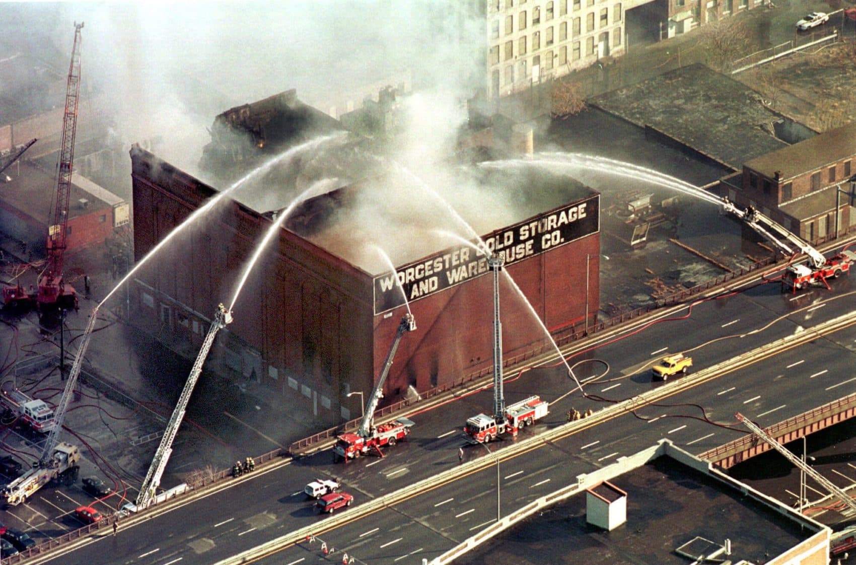 In this 1999 photo, firefighters spray water onto the burning Worcester Cold Storage and Warehouse Co. building, where six Worcester firefighters lost their lives. (Paul Connors/AP)