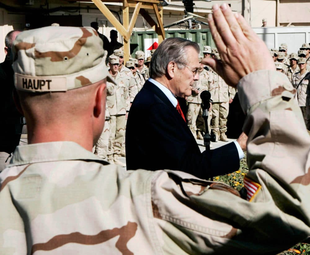 SPC Steven Haupt of the 173rd Airborne (L) raises his hand to take his re-enlistment oath from US Secretary of Defense Donald Rumsfeld during a ceremony 22 December 2005 in Khandahar, Afghanistan before Rumsfeld left for Baghdad. (Jim Young/AFP via Getty Images)